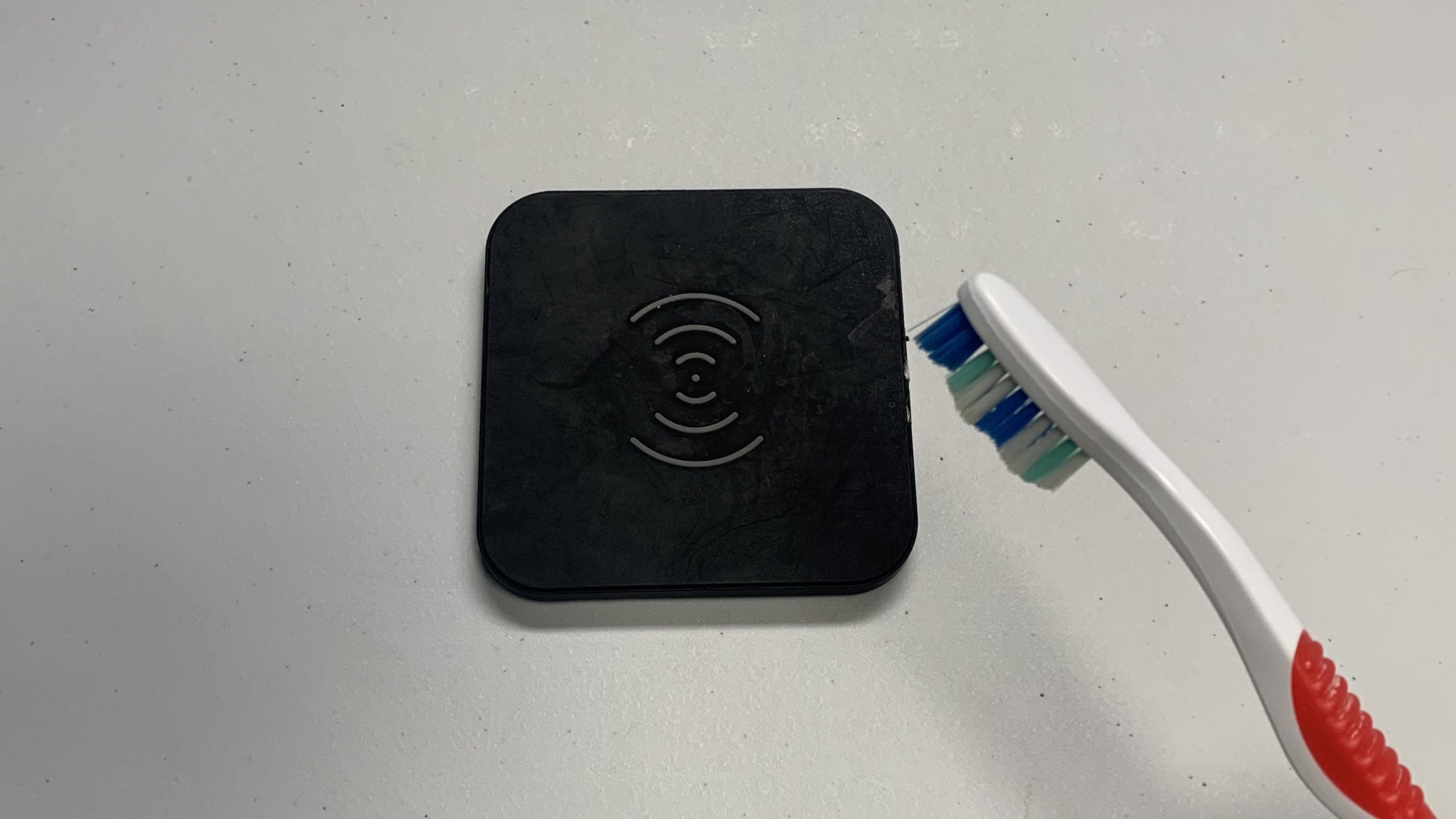 brush away debris on wireless charger with a clean toothbrush